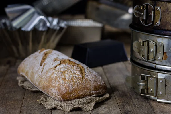 ขนมปังสดและกรอบกับดอกทานตะวันบนโต๊ะไม้ ขนมปัง — ภาพถ่ายสต็อก