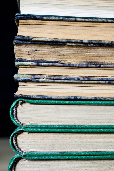 The spines of old books lying on the stack. Books stacked on an