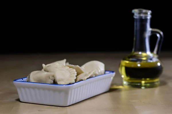 Läckra dumplings ordnade på en ljus trä köksbord. Dumpli — Stockfoto