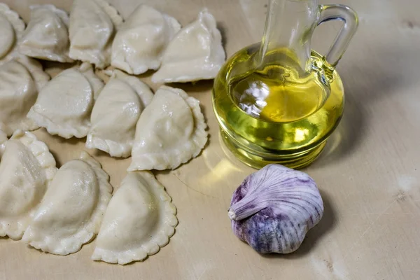 Sabrosos dumplings dispuestos en una mesa de cocina de madera clara. Dumpli. —  Fotos de Stock
