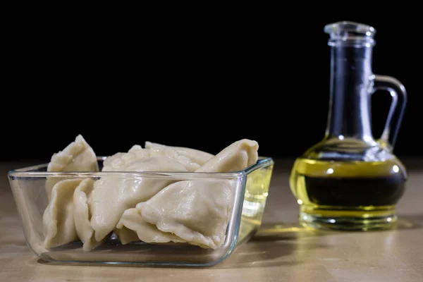 Läckra dumplings ordnade på en ljus trä köksbord. Dumpli — Stockfoto