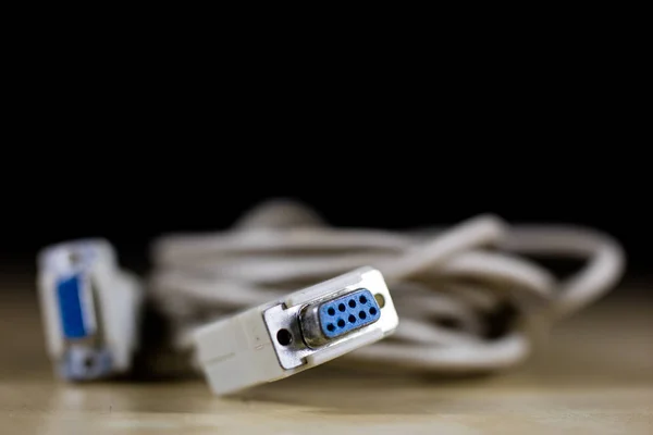 Cabos elétricos, plugues e conectores em uma mesa de oficina de madeira — Fotografia de Stock