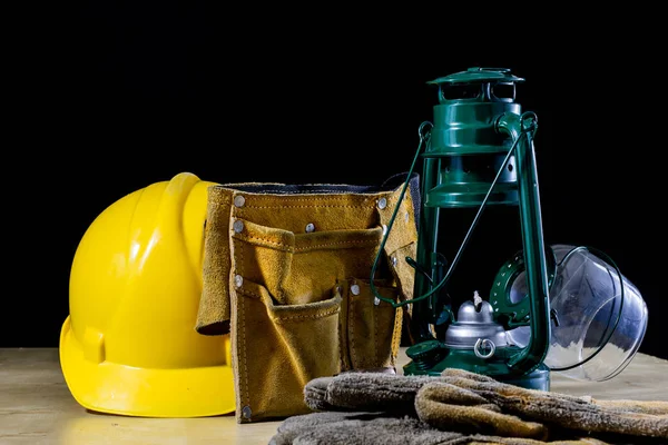 Lámpara de aceite, casco y zapatos en una mesa de taller de madera. De los trabajadores —  Fotos de Stock