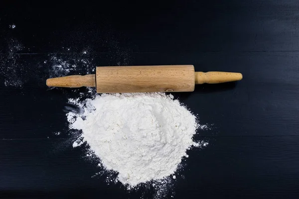 Mehl und Nudelholz zum Kneten des Teiges auf dem Küchentisch — Stockfoto