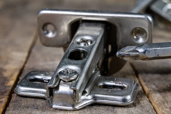 Een houtbewerking scharnier op een houten workshop tafel. Schrijnwerkerij accessoires — Stockfoto