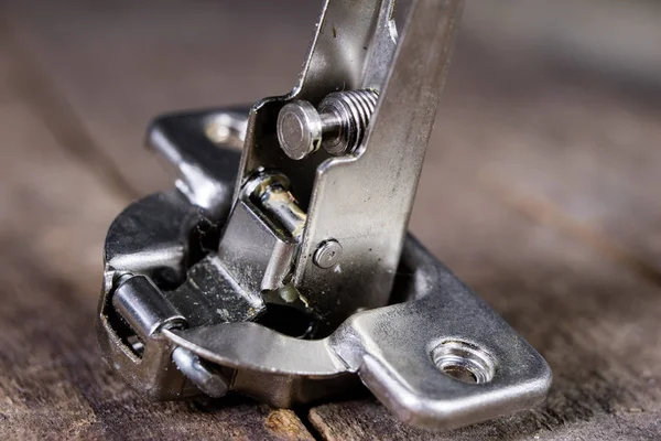 Een houtbewerking scharnier op een houten workshop tafel. Schrijnwerkerij accessoires — Stockfoto