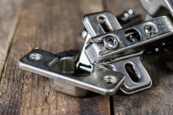 Een houtbewerking scharnier op een houten workshop tafel. Schrijnwerkerij accessoires — Stockfoto