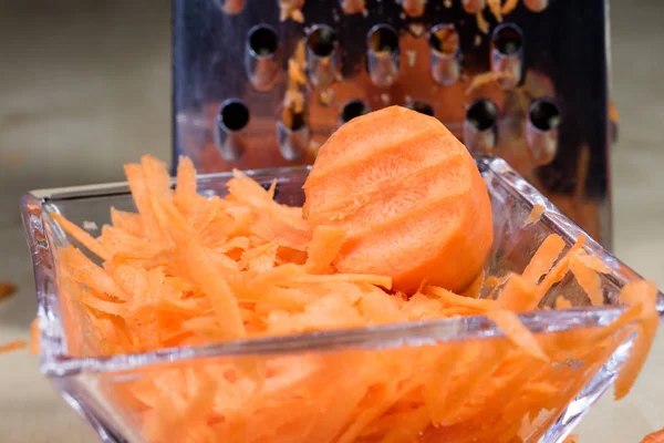 Морковь взлетает на кухонной терке. Столешница и пре — стоковое фото