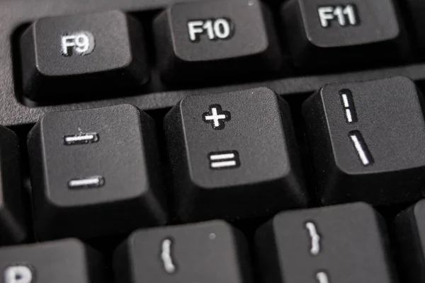 An enlarged computer keyboard. Black keyboard buttons for the co — Stock Photo, Image