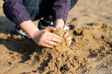 Çocuklar tarafından kum üzerinde bina kaleler. Bahar eğlence göl.
