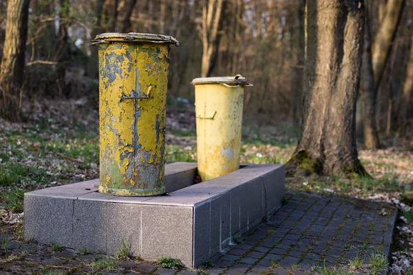 Un viejo cubo de basura. Depósitos de basura colocados en un parque entre árboles — Foto de Stock