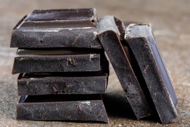 Siyah çikolata küpleri kırık ve birbirlerine yığılmış. Tatlı de