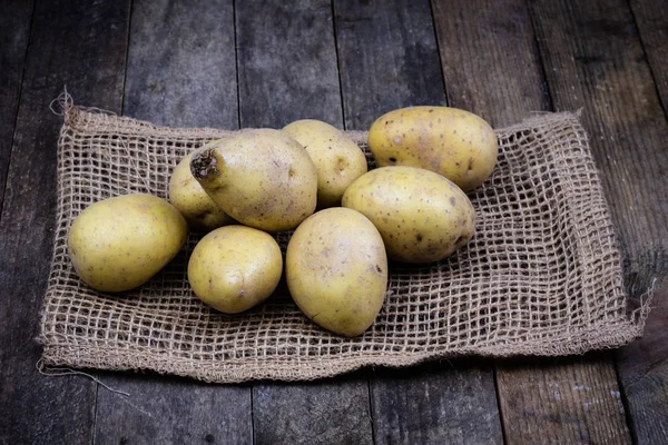 Batatas saborosas em uma mesa de madeira. Legumes na mesa da cozinha — Fotografia de Stock