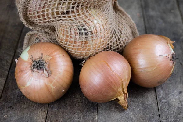 Tasty ripe onion in a jute sack. Vegetables hollowed out in the — Stock Photo, Image