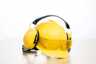 Koruyucu kask ve iş botları ahşap bir masaya. Güvenlik ve h