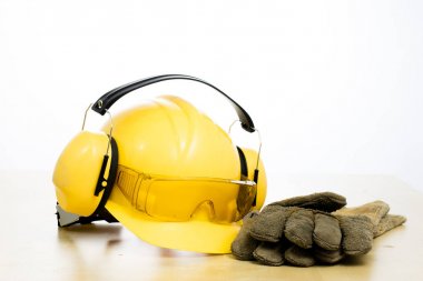 Koruyucu kask ve iş botları ahşap bir masaya. Güvenlik ve h