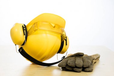 Koruyucu kask ve iş botları ahşap bir masaya. Güvenlik ve h