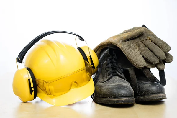 Casque de protection et bottes de travail sur une table en bois. Sécurité et h — Photo