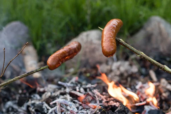 Smakrik korv beredd på lägerelden. En semester måltid tillagad — Stockfoto