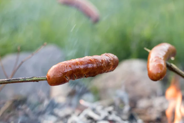 Tasty sausage prepared on the campfire. A holiday meal prepared — Stock Photo, Image