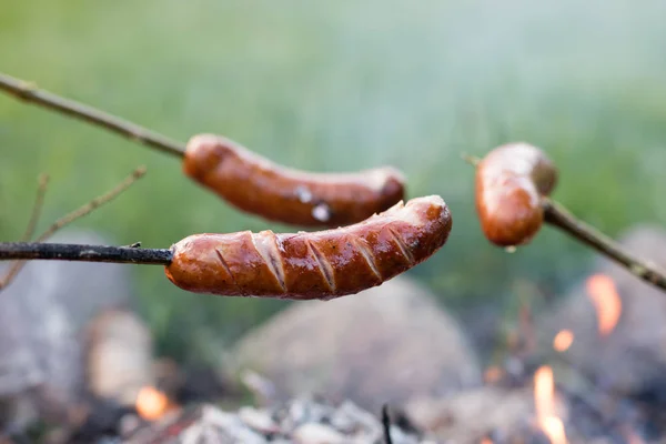 Smakrik korv beredd på lägerelden. En semester måltid tillagad — Stockfoto