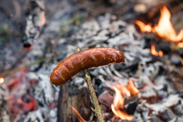 Smakrik korv beredd på lägerelden. En semester måltid tillagad — Stockfoto