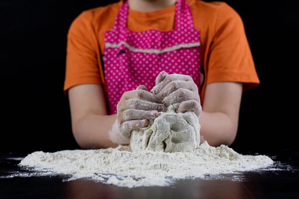 Kneading dough on a black table in a bakery. Baker's hands prepa — Stock Photo, Image