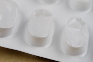 Ahşap bir masa üzerinde bir sarmalayıcı hap. Soğuk algınlığı için bir ilaç ve 