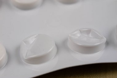 Ahşap bir masa üzerinde bir sarmalayıcı hap. Soğuk algınlığı için bir ilaç ve 