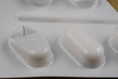 Ahşap bir masa üzerinde bir sarmalayıcı hap. Soğuk algınlığı için bir ilaç ve 