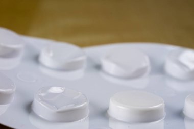 Ahşap bir masa üzerinde bir sarmalayıcı hap. Soğuk algınlığı için bir ilaç ve 