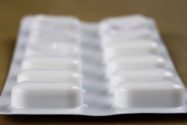 Ahşap bir masa üzerinde bir sarmalayıcı hap. Soğuk algınlığı için bir ilaç ve 