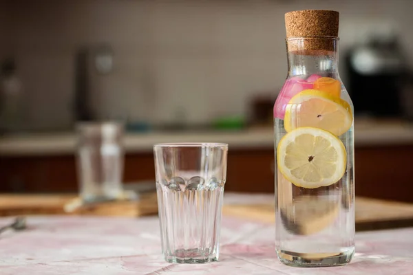 Свежая вода с лимоном. Освежающий напиток в стеклянном контейнере — стоковое фото