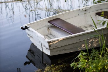 Bir balıkçı teknesi göl kıyıya demirlemiş. Eski balıkçı 
