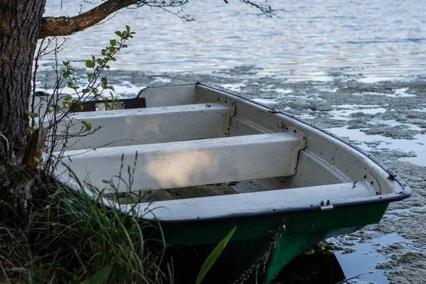A fishing boat moored to the shore of the lake. Old fishermen's — Stock Photo, Image