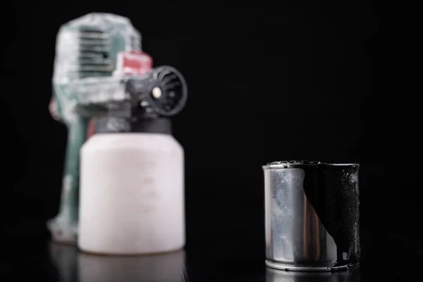 Pulverizador de tinta elétrica suja e latas de tinta . — Fotografia de Stock
