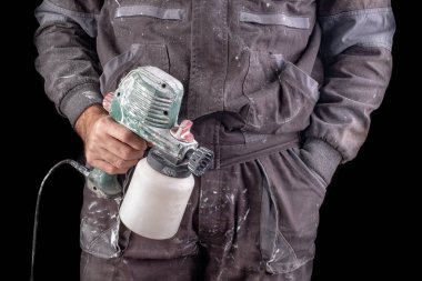 Boyacı elinde elektrikli boya tabancası tutuyor..