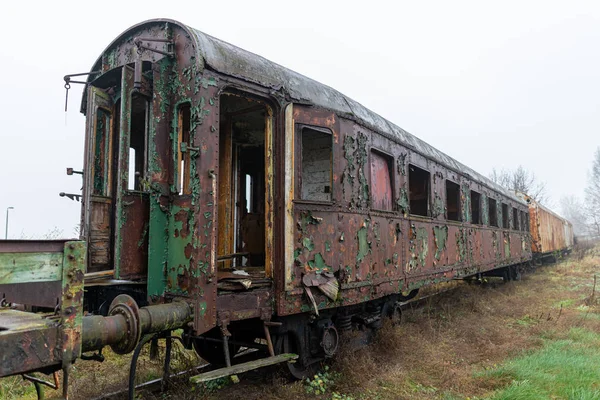 Viejas locomotoras oxidadas y vagones de pie en una pista lateral . — Foto de Stock