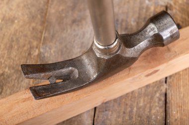 Bir marangoz bacağı kullanarak bir tahta parçasından çivi çıkarmak.