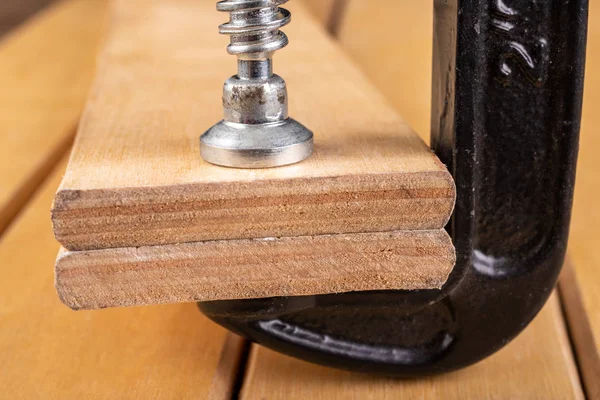 Morsetto di legno di metallo su un tavolo di officina . — Foto Stock