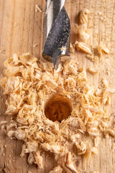 Drilling with a drill bit into wood. Small carpentry work in a c — Stock Photo, Image
