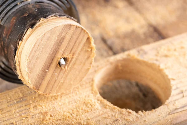 Drewniana piła i surowa deska. Robienie otworów w drewnie surowym. — Zdjęcie stockowe