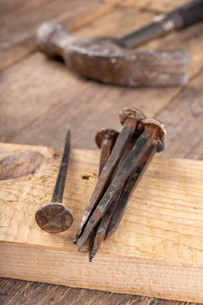 Old rusty nails on a workbench. Steel elements forged in old tec — Stock Photo, Image