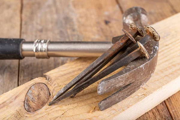 Viejos clavos oxidados en un banco de trabajo. Elementos de acero forjados en tecnología antigua —  Fotos de Stock