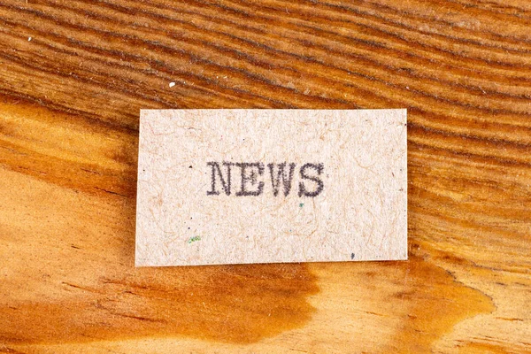 Das Wort "Nachrichten" eingetippt. die Inschrift auf einem grauen Blatt Pappie — Stockfoto