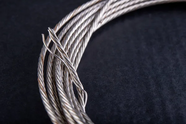 Cuerda de acero enrollada en un bucle. Accesorios en un taller casero . — Foto de Stock