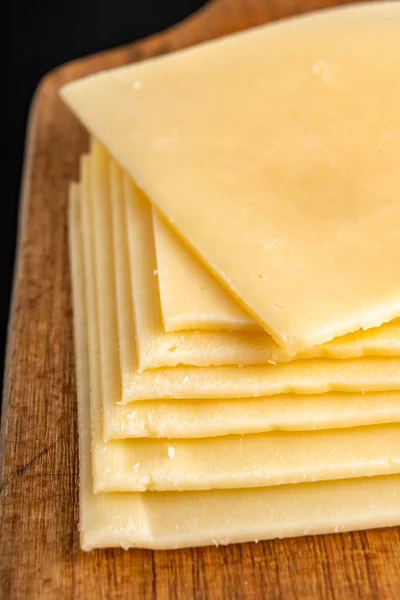 Кусочки желтого сыра на деревянной доске. Продукты питания с рынка — стоковое фото