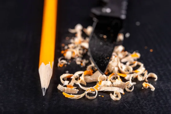 Een potlood slijpen met een zakmes. Kantoorwerk thuis. — Stockfoto