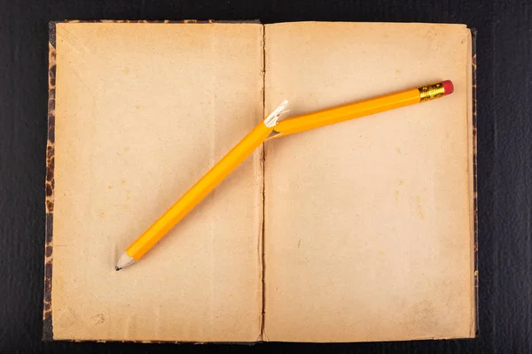 Złamany ołówek i stara książka. Emocje podczas pracy biurowej. — Zdjęcie stockowe