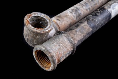 Su kaynağı için eski kirli metal boru. Tesisatçı için aksesuarlar ve aletler. Koyu arkaplan.